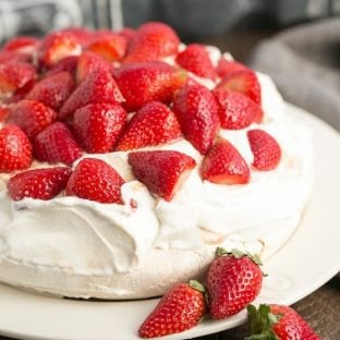 Strawberry Pavlova | A large "squidgy" meringue shell topped with a pillow of whipped cream and balsamic strawberries