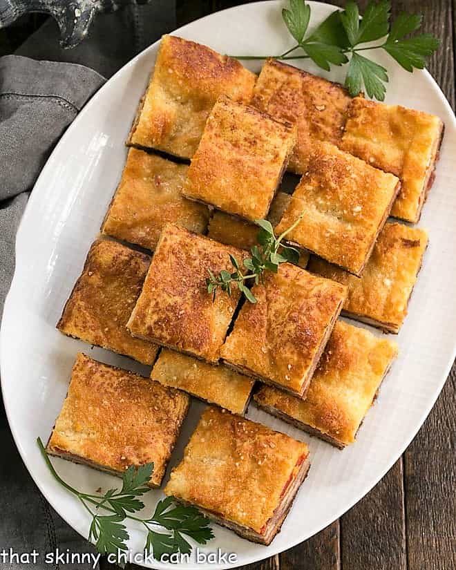 Overhead view of Antipasto Squares on a white oval platter.