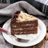 Slice of German Chocolate Cake on a dessert plate with a red fork