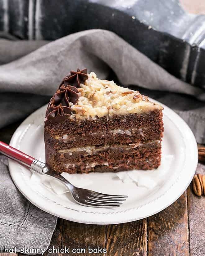 Slice of German Chocolate Cake on a dessert plate with a red fork