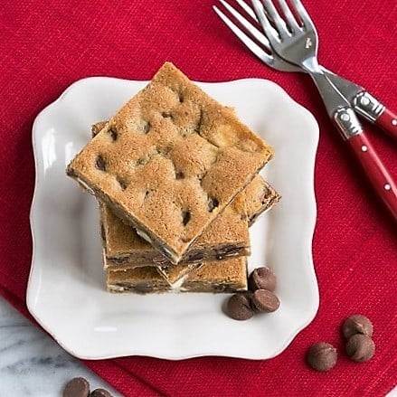 Cookie Bars filled with 3 kinds of chocolate chips - Kid friendly, super easy chocolate chip cookie dessert! Overhead view of a stack of Homemade Chocolate Chip Bars.
