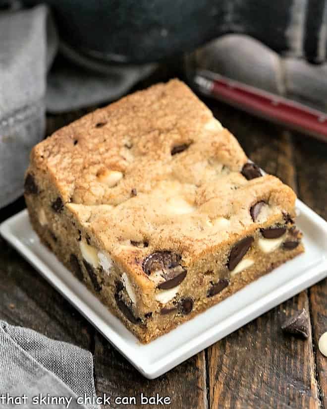 One chocolate chip cookie bar on a square white plate