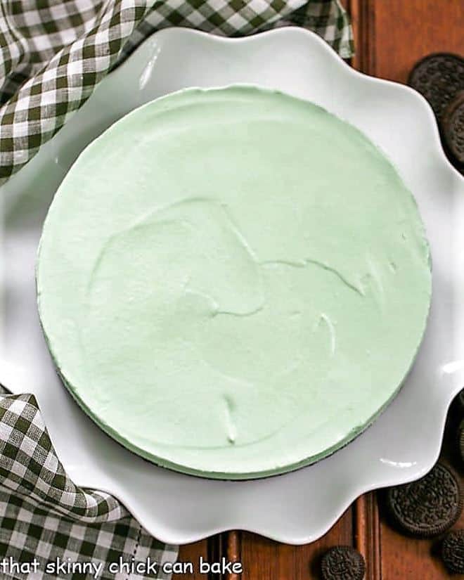Frozen Mint Pie with an Oreo Crust - Mint lovers will swoon with every bite of this frozen dessert! Frozen Grasshopper Pie with an Oreo Crust on a white ceramic serving platter.