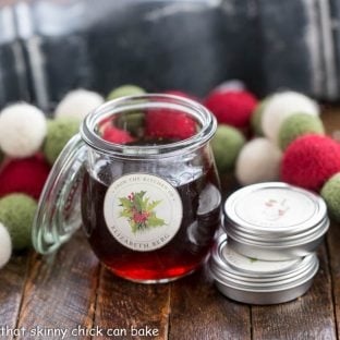 A jar of vanilla extract next to 2 tins of labels