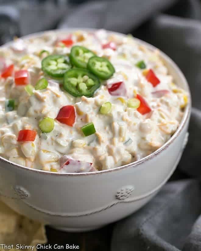 Sour Cream Corn Dip side view in a white ceramic bowl garnished with jalapeno slices