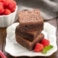 3 Rich Fudgy Cocoa Brownies stacked on a white plate
