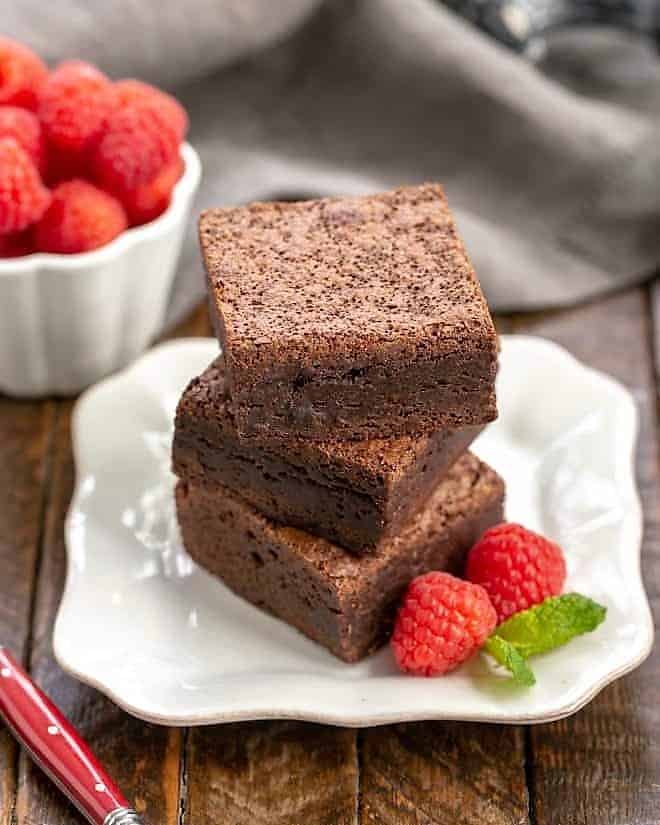 3 Rich Fudgy Cocoa Brownies stacked on a white plate