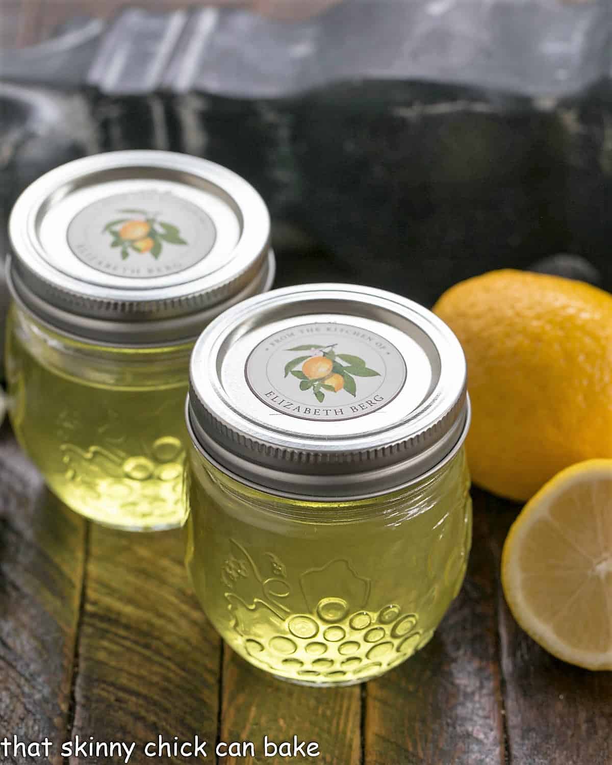 Homemade Limoncello in 2 glass jars with fresh lemons.