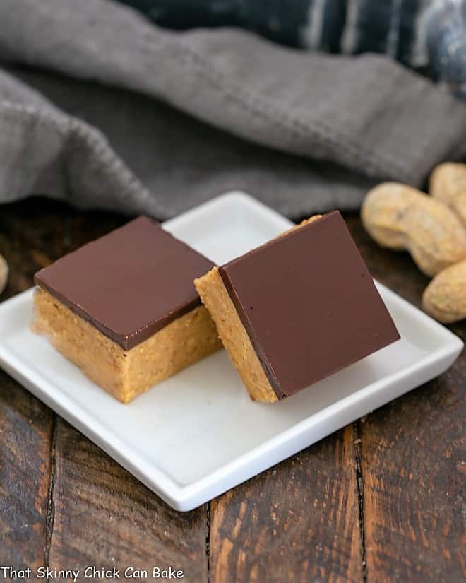 Better Than Reese's Peanut Butter Bars - Easy No-Bake Peanut Butter Bars that provide your Reese's fix!!! Two Better Than Reese's Peanut Butter Bars on a square white plate.