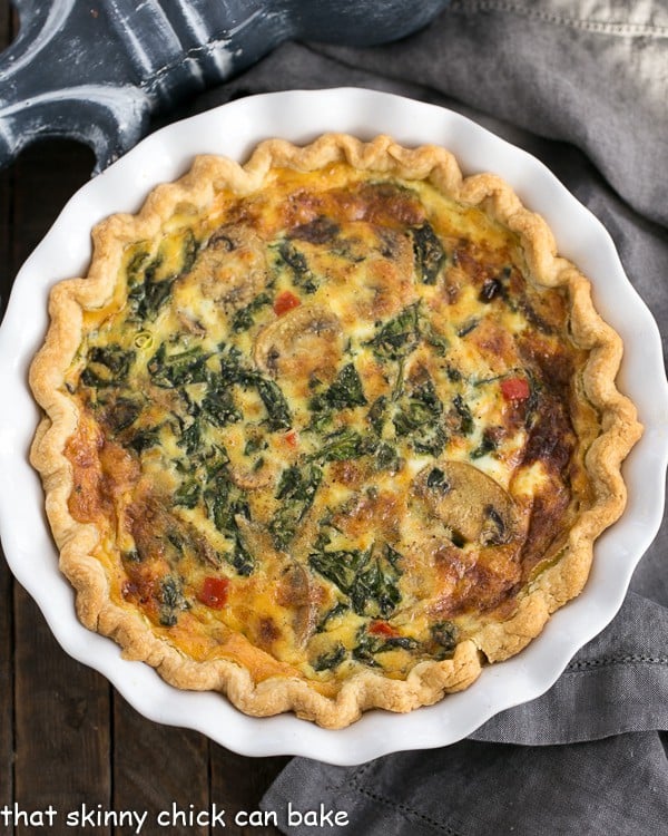 Spinach Mushroom Quiche in a white pie plate.