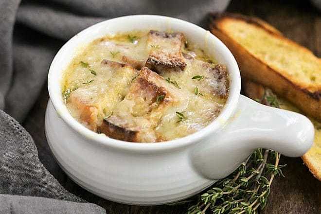 Classic French Onion Soup - A rich onion laden broth flavored with herbs, white wine and cognac and topped with cheesy toast!