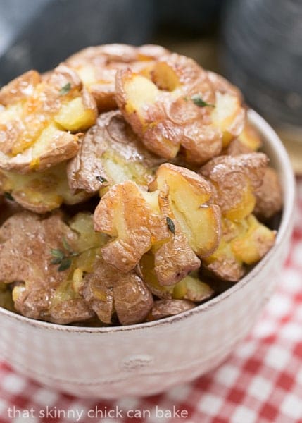 Crsipy Smashed Potatoes in a white serving bowl.