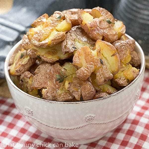 Crispy Smashed Potatoes in a white bowl on a red and white checked napkin.