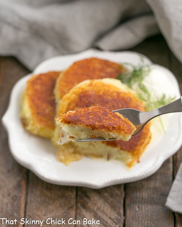 Gruyere Potato Cakes with a bite on a fork in the foreground