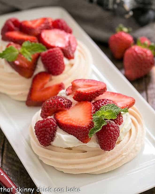 Two individual pavlovas on a white tray