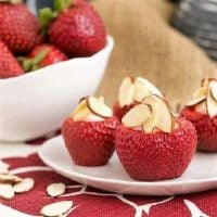 Cheesecake stuffed strawberries on a small white plate