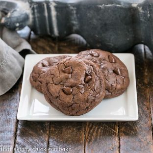 3 chocolate cookies on a square white ceramic plate