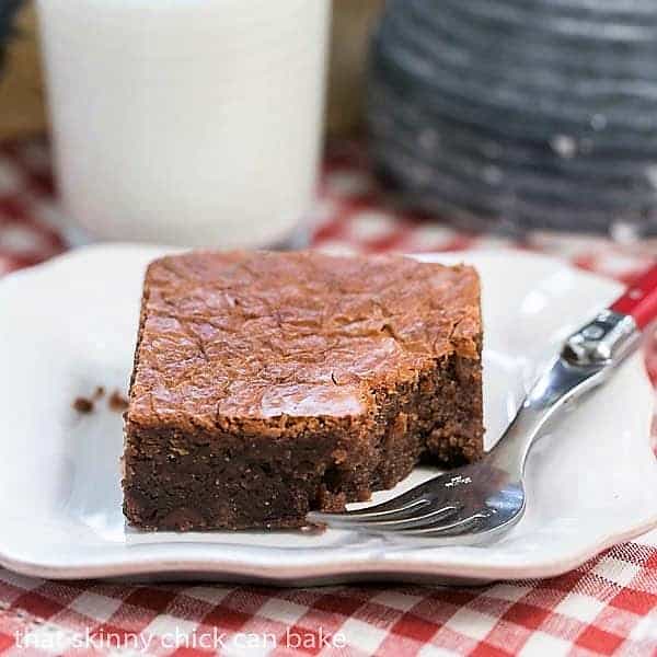 One Fat Witch Brownie on a white plate with a red handled fork with a bite removed