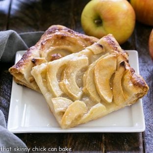 2 slices of apple tart on a square white ceramic plate