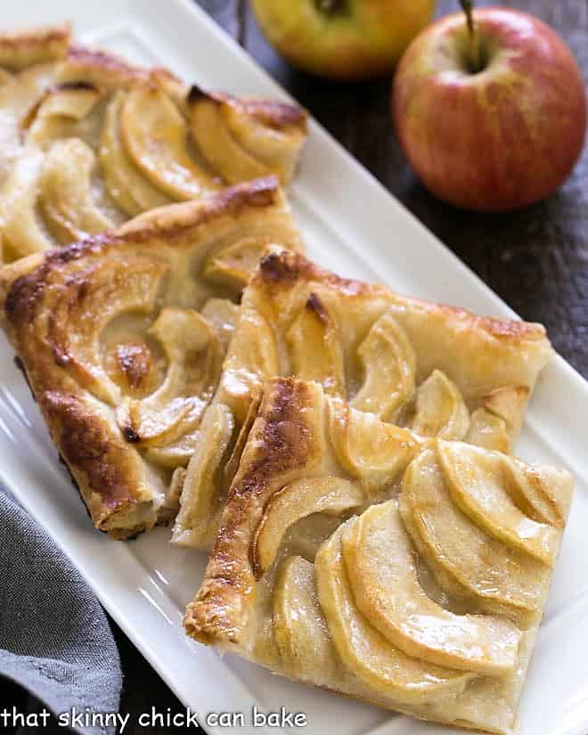 Slices of French Apple Tart on a white ceramic tray.