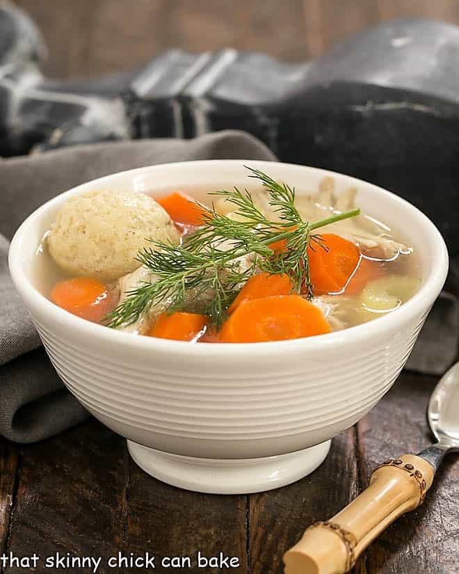 Side view of Matzo Ball soup in a white bowl.