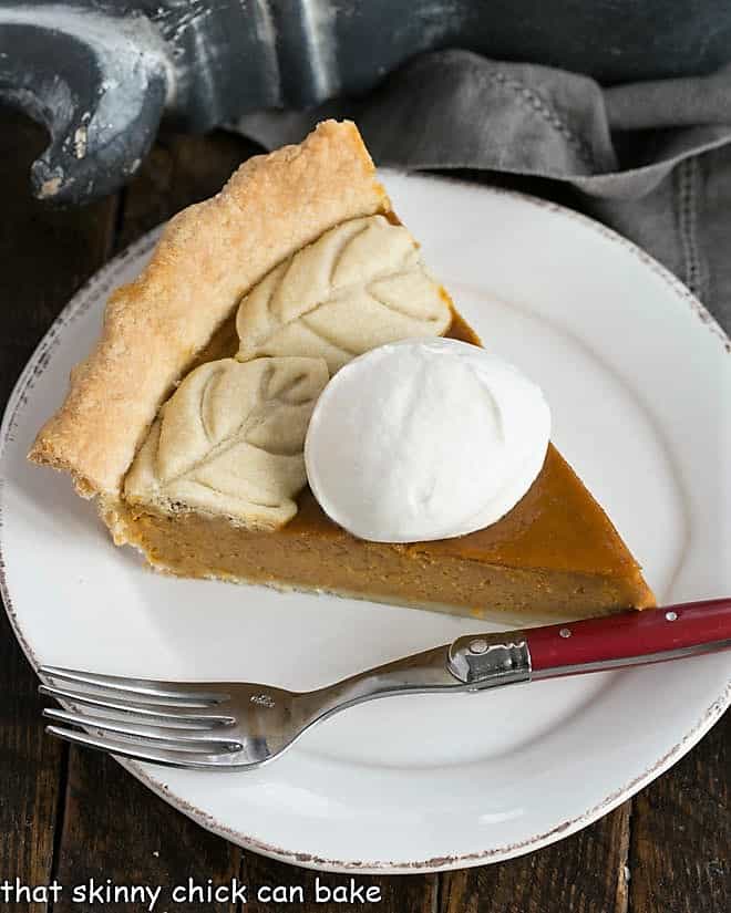 Overhead view of a Pumpkin Pie slice garnished with whipped cream.
