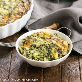 A small white bowl filled with spinach souffle