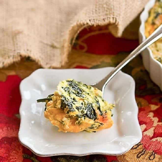 Spinach Souffle - An easy, cheesy spinach casserole that makes a terrific side dish! Perfect for the holidays. A spoonful of Spinach Souffle on a small white plate