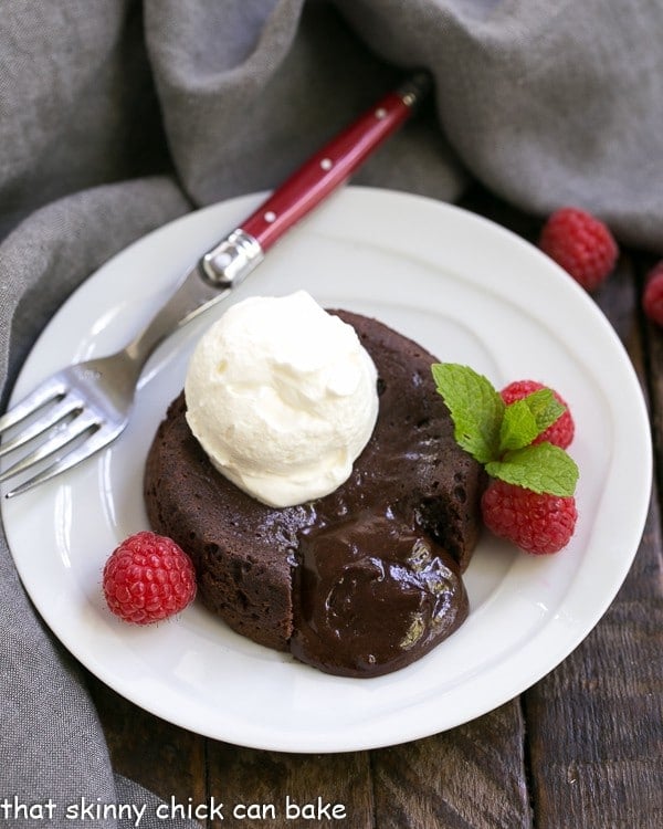 Oozing Molten Lava Cake on a white plate with a scoop of ice cream and berries