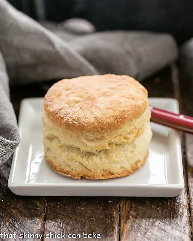 A Buttermilk Biscuit on a square white plate with a red handled knife