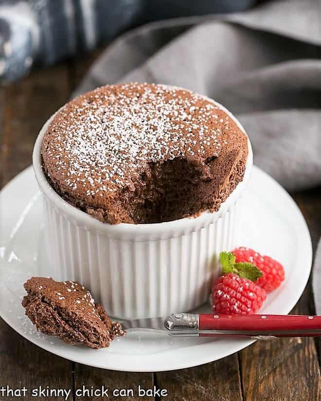Individual Individual Chocolate Soufflés with a spoonful removed to reveal the interior