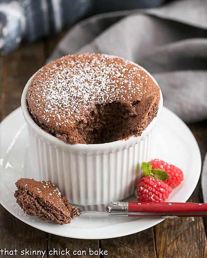 Individual Individual Chocolate Soufflés with a spoonful removed to reveal the interior.