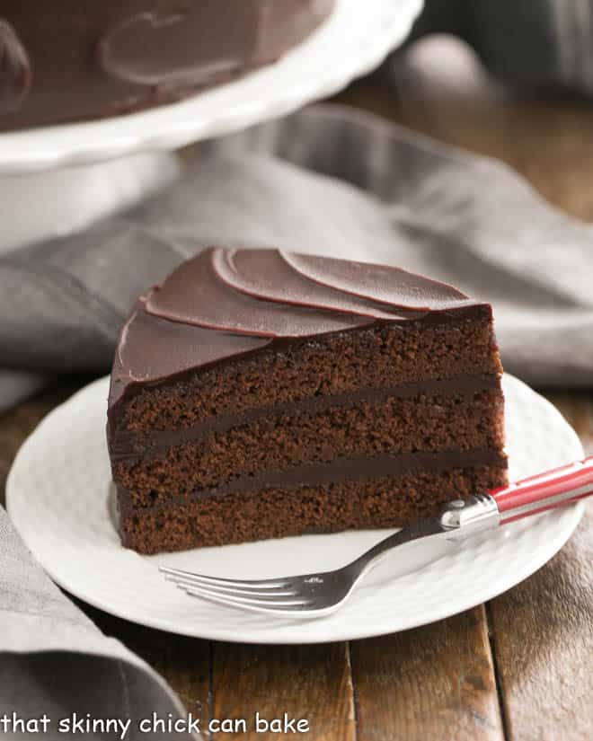 Slice of Triple Layer Cocoa Cake on a white dessert plate.