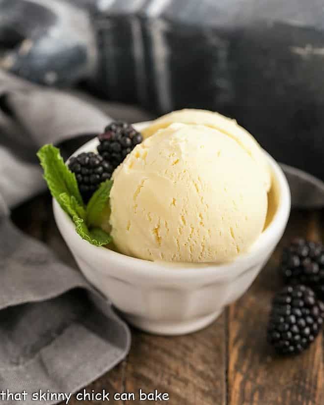 White Chocolate Ice Cream in a white bowl with blackberries and mint