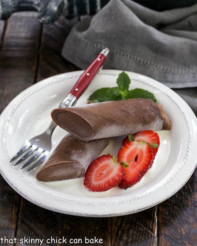 Frozen chocolate crepe sliced in half and served over creme Anglaise with sliced strawberries