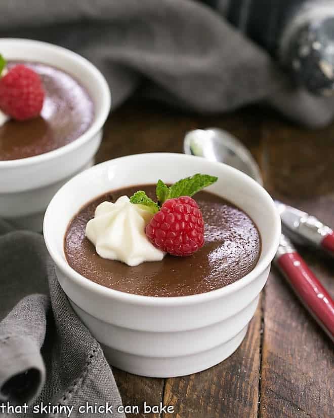 Chocolate Pots de Crème with White Chocolate Whipped Cream in white ramekins.