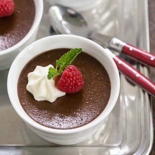 Chocolate Pots de Creme on a silver tray with red handled spoons