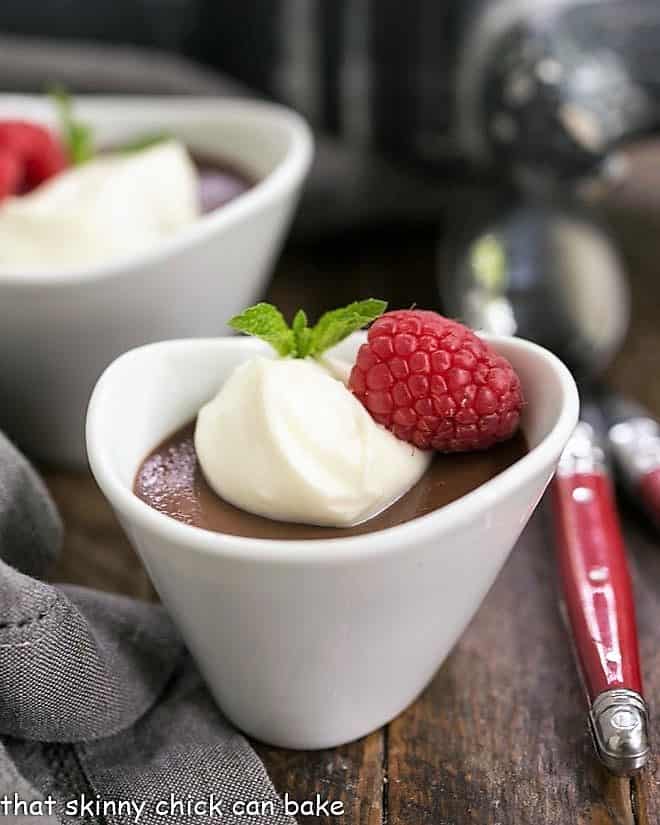 Chocolate Pots de Creme topped with white chocolate cream and raspberries