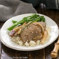 Pork bulgoi on a round white plate over rice with broccolini