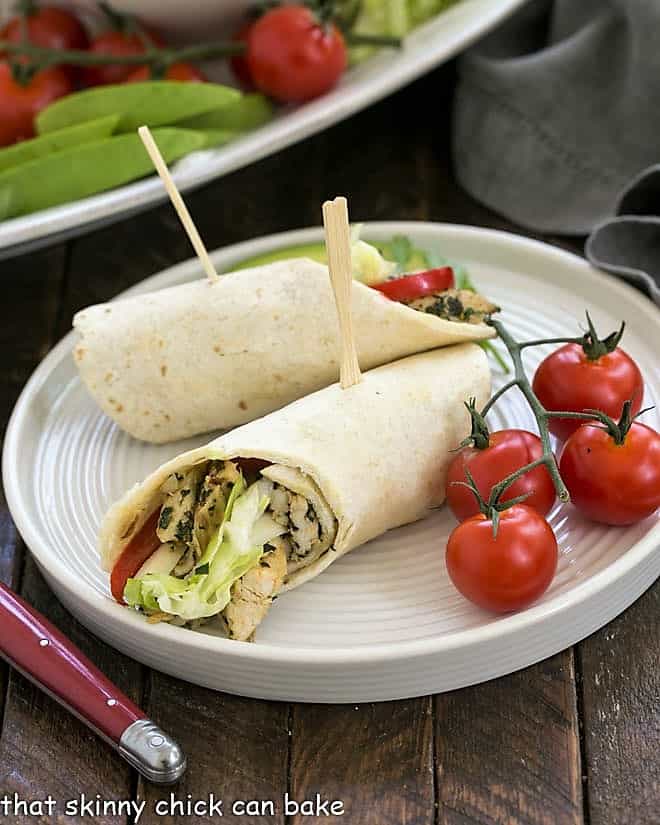 Chicken taco on a white plate with a fresh cherry tomato garnish