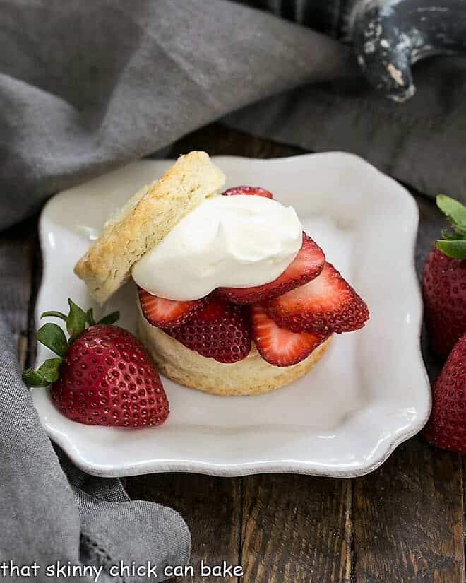 Classic Strawberry Shortcakes on a square white plate with a half strawberry garnish.