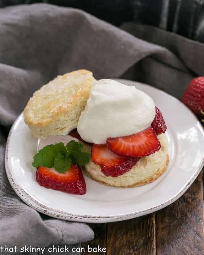 Classic Strawberry Shortcake on a round white plate with a sprig of mint
