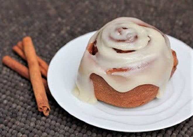 Frosted Classic Cinnamon Roll on a white plate