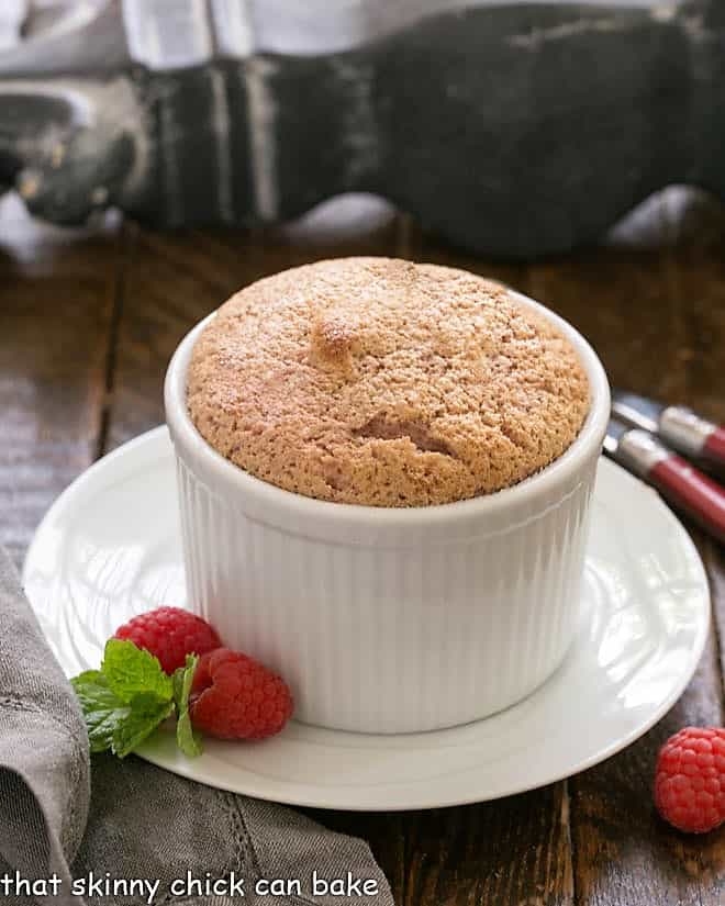 Individual Raspberry Souffle on a white plate with a raspberry garnish.