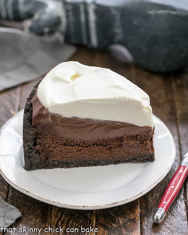 Mississippi Mud Pie - a decadent layered dessert with an Oreo crust topped with a flourless chocolate cake, then silky chocolate pudding and whipped cream Slice of Mississippi Mud Pie on a white plate.