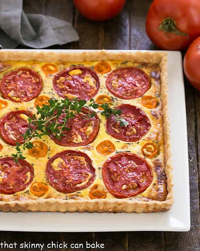 Overhead view of Tomato Gruyere Tart on a square white platter