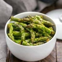 Stir fried asparagus in a white bowl