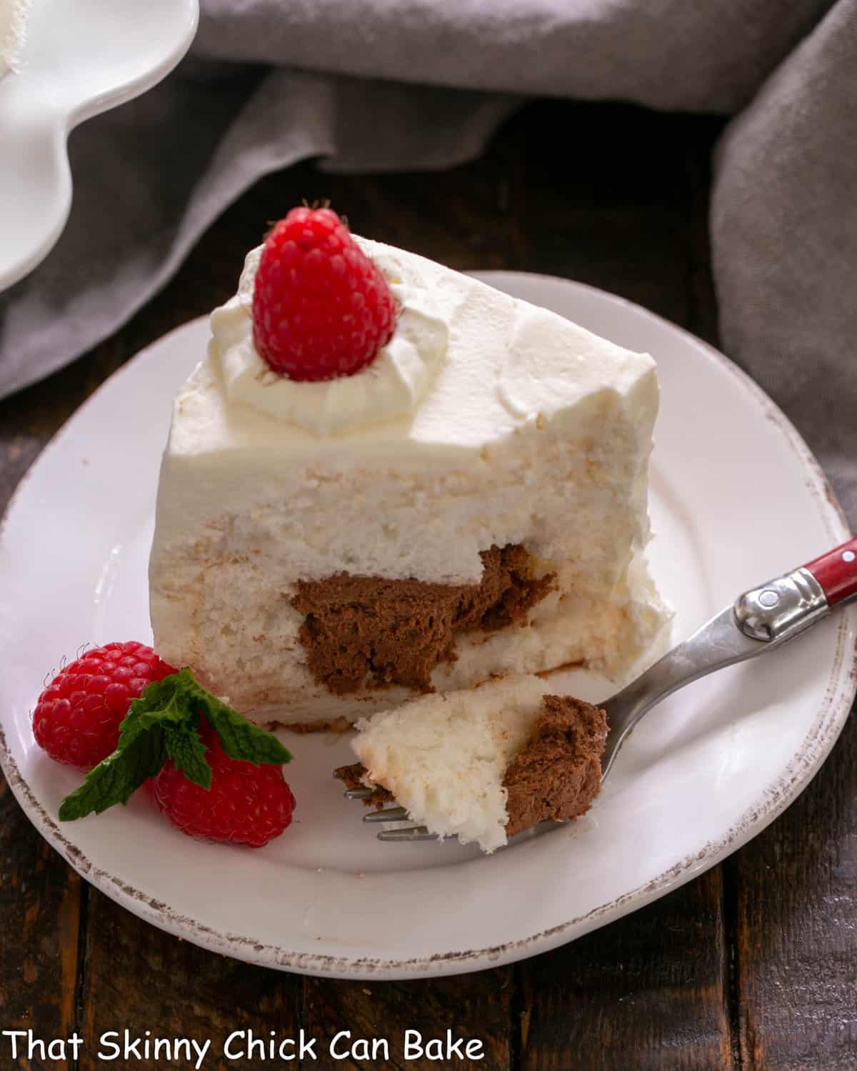Slice of filled angel food cake with a forkful removed.