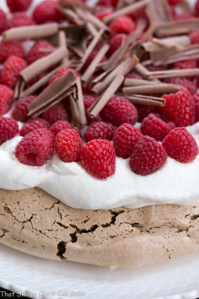 Edge of a Chocolate Raspberry Pavlova topped with chocolate shavings.