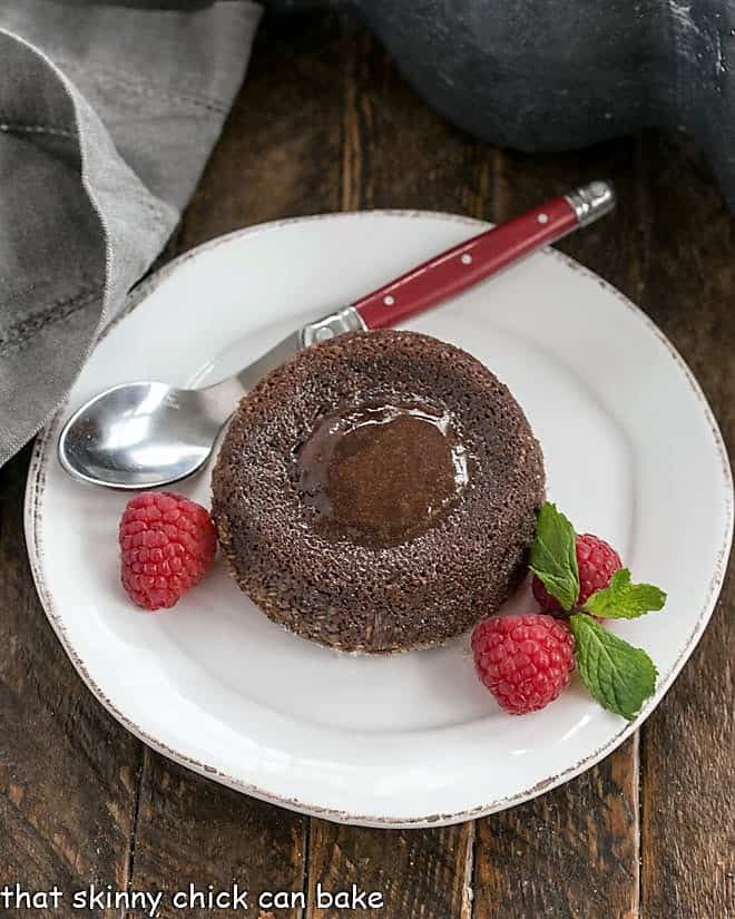 Overhead view of a molten lava cake with raspberries